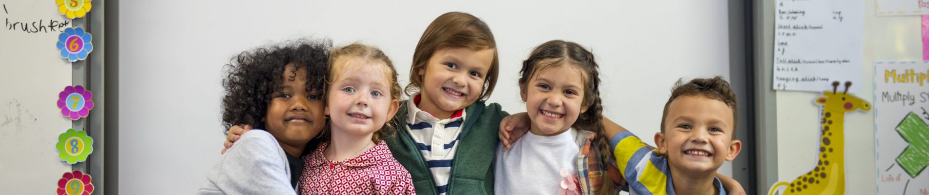 Young students in front of a white board