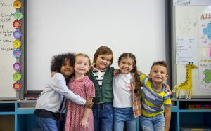 Young students in front of a white board